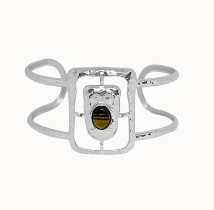 Astrid Cuff Silver - Mountain & Moon 

Description
The Astrid Cuff in silver brings a more elevated, more directional energy. An open rectangular frame - in cool silver with a Tigers Eye stone at the centre, its warm amber tones creating a striking contrast against the polished metal.
Part of the Odyssey collection - for the woman in motion, who dresses with instinct.

Micron 18K gold & sterling silver plating 
to premium jewellery standards