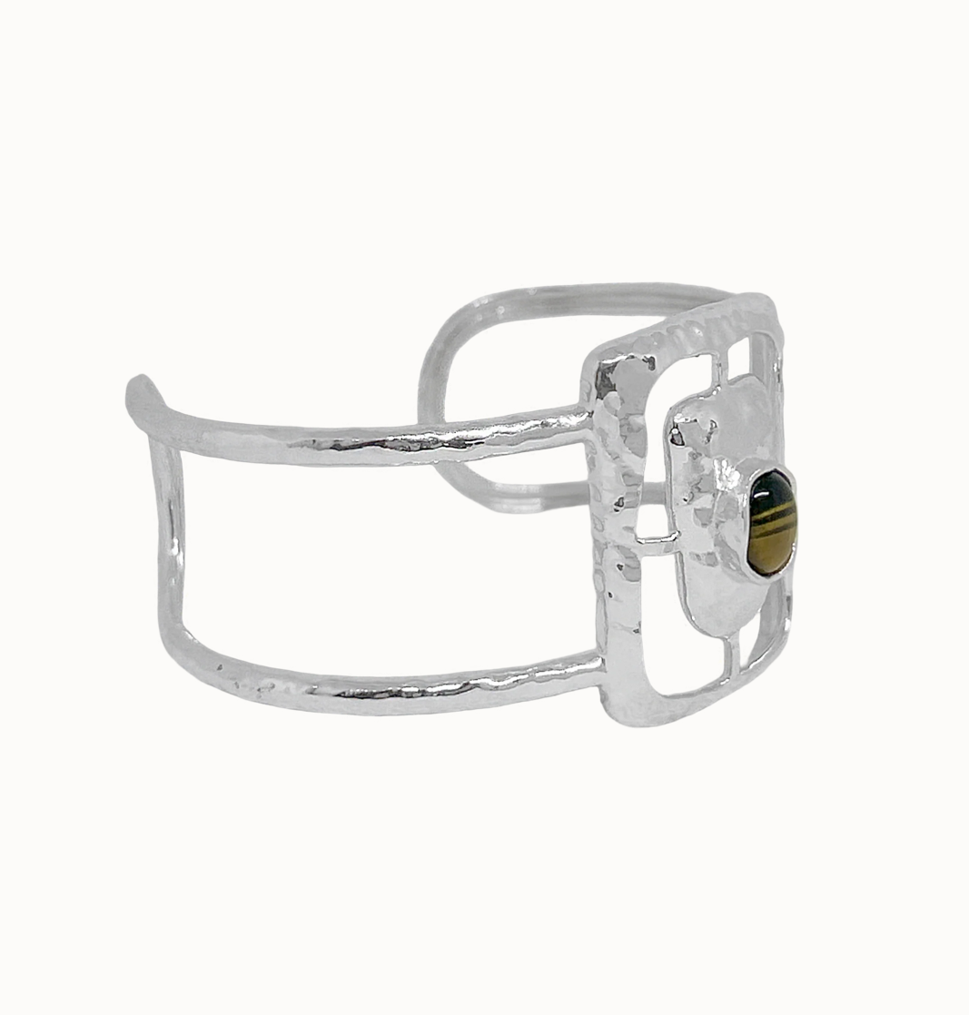 Astrid Cuff Silver - Mountain & Moon 

Description
The Astrid Cuff in silver brings a more elevated, more directional energy. An open rectangular frame - in cool silver with a Tigers Eye stone at the centre, its warm amber tones creating a striking contrast against the polished metal.
Part of the Odyssey collection - for the woman in motion, who dresses with instinct.

Micron 18K gold & sterling silver plating 
to premium jewellery standards