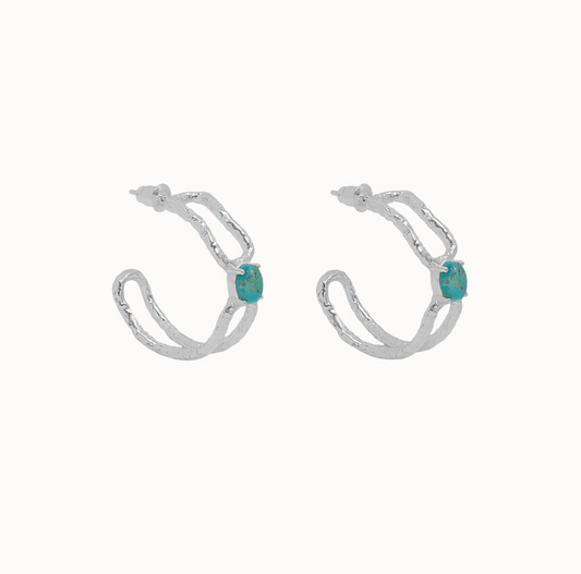 Sascha Earrings Silver - Mountain & Moon 

Description

ELEVATED ESSENTIALS • WEAR ON REPEAT

The Sascha Earrings bring sculptural sophistication to your everyday rotation. 
An organic, open double-hoop silhouette anchored by a vibrant Blue Mojave Turquoise gemstone at its centre - an unexpected focal point that feels both grounded and playful. Softly textured silver catches the light, adding dimension and a subtle vintage-inspired edge.