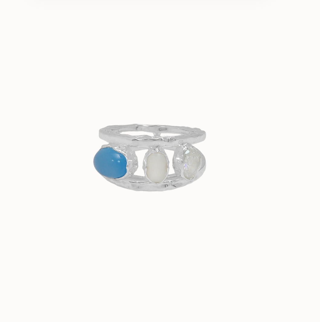 LAYERED STYLE • MODERN KEEPSAKE

Maral in silver feels lighter, cooler, and quietly striking. Two slender hammered bands frame three distinct stones — freshwater pearl, blue chalcedony, and white CZ — each set in organic bezels that give the piece an imperfect, lived-in beauty.

There’s a tension between delicacy and strength here. The double band creates structure, while the stones bring softness and light. It reflects the instinctive, material-led approach behind the Dominique Elissa x Mountain & Moon 