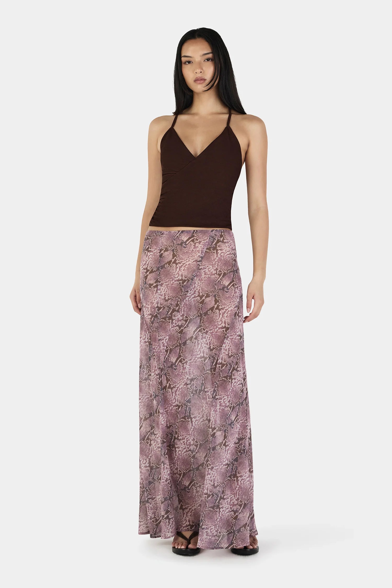 The Erin Top in Chocolate by OWNLEY is a cami top silhouette. Designed in a flattering wrap silhouette, it features light gathering at the side seams, with a twist rope inspired straps. The backless design adds a striking finish, while the front is fully self-lined for support and coverage.