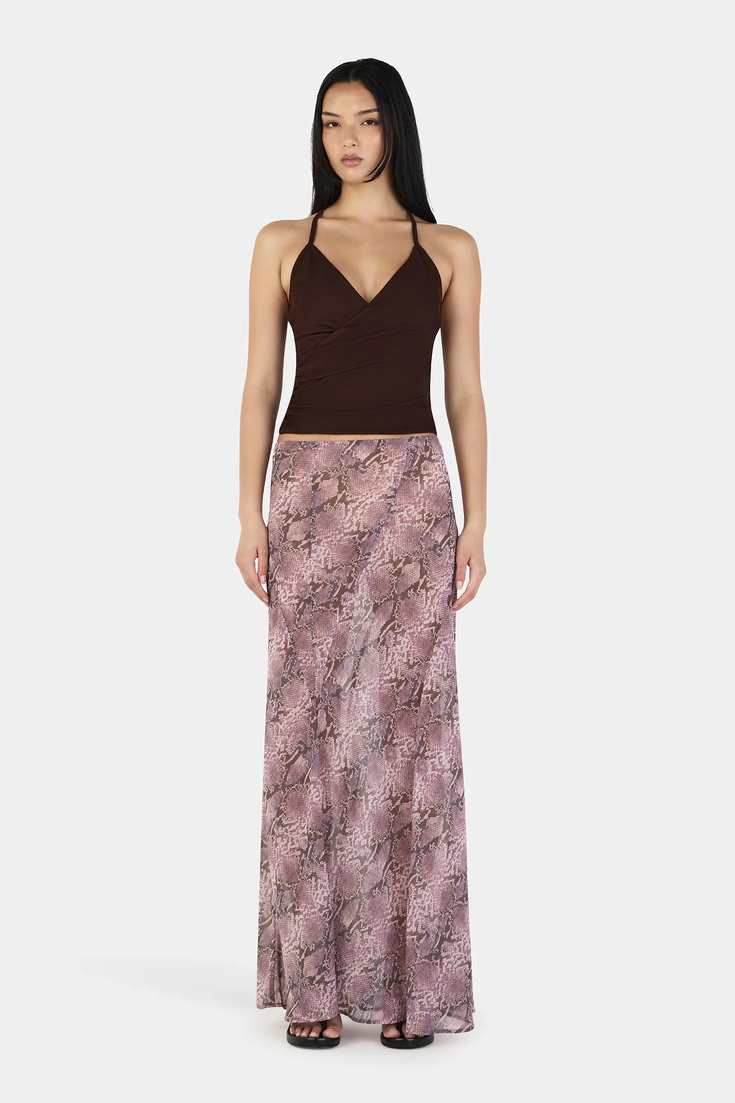 The Erin Top in Chocolate by OWNLEY is a cami top silhouette. Designed in a flattering wrap silhouette, it features light gathering at the side seams, with a twist rope inspired straps. The backless design adds a striking finish, while the front is fully self-lined for support and coverage.