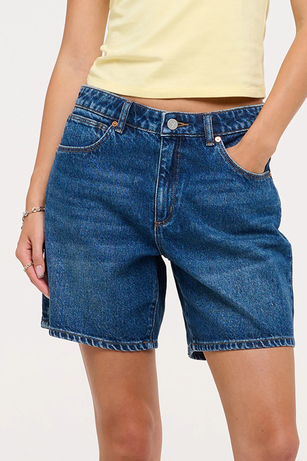 The '95 Relaxed Short by Abrand delivers effortless style with a mid-rise fit and generous 17cm in the leg. A comfortable wide leg opening and classic 5-pocket design provide everyday versatility. Mid-indigo wash with softened whisker details creates that lived-in aesthetic, while bright copper and silver trims and a tan dice patch add character. Crafted from a sustainable 50% Cotton and 50% Recycled Cotton blend, it's comfort and conscience combined.
