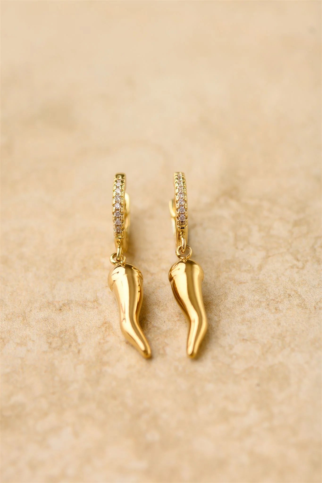 Add a little spice to your style with Oro! These charm earrings feature a golden chilli on a cubic zircon hoop, adding a playful twist to any outfit. Who says fashion can't be hot!

925 Gold Plated Sterling Silver 
Cubic Zircon
Lead,Nickel & Tarnish Free
Hypoallergenic
Waterproof