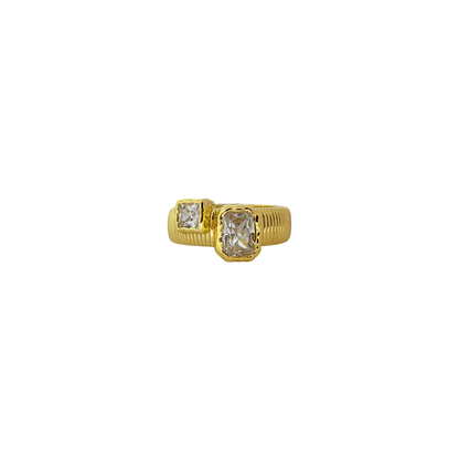 Elegant with a hint of edge, the Maia Ring is a modern relic inspired by radiant ancient craftsmanship. Featuring a ribbed, circular band in gold, it holds two rectangular cubic zirconia stones in textured bezel settings—designed to catch the light like sunlit waves.