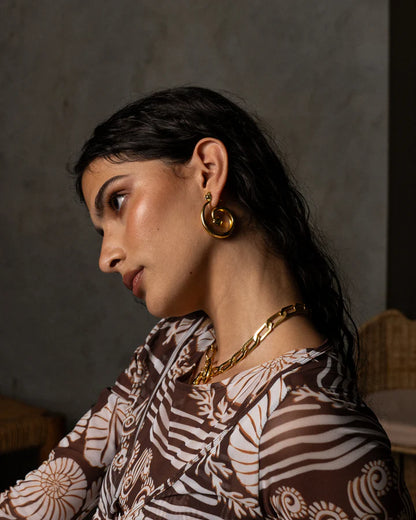 These beauties boast ethereal beauty and earthy grounding, the GAIA Earrings in Gold will have you feeling like a sophisticated goddess. Inspired by the beauty of natural stone and the&nbsp;fluidity of water, these chic hoop style earrings feature an elegant spiral motif that adds a chic touch to any look, and displaying faceted sparkling White CZ stones. A must-have for those who are looking to effortlessly standout.