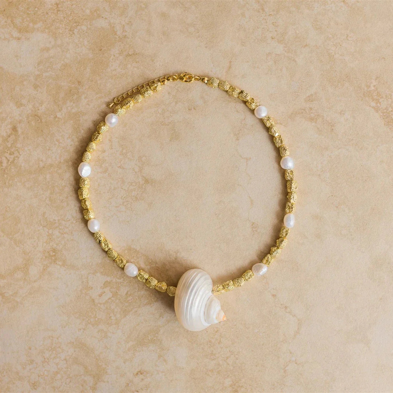 Embrace the ocean's beauty with our PARADISO Necklace! Crafted from luxurious gold vermeil, this stunning necklace features a conch shell pendant that will transport you to the seaside. 

24Kt Crushed Gold Vermeil
Freshwater Pearl/Conch Shell
Lead,Nickel & Tarnish Free
Hypoallergenic