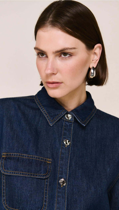 The Lea Denim Cropped Short-Sleeve Shirt is a modern take on classic denim, designed with a structured cropped silhouette and clean, tailored lines. Crafted from a soft cotton and lyocell blend, it offers a comfortable, lightweight feel while maintaining a polished finish - perfect for elevated everyday styling.

