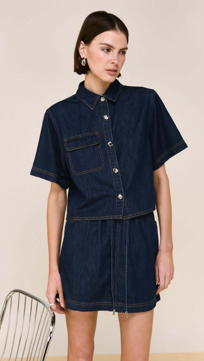 The Lea Denim Cropped Short-Sleeve Shirt is a modern take on classic denim, designed with a structured cropped silhouette and clean, tailored lines. Crafted from a soft cotton and lyocell blend, it offers a comfortable, lightweight feel while maintaining a polished finish - perfect for elevated everyday styling.

