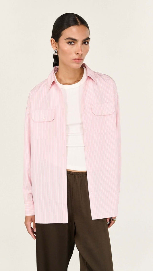 The Lina Pink Pinstriped Shirt is a modern wardrobe essential designed with a relaxed silhouette and timeless shirting details for effortless everyday wear. Crafted from a lightweight woven fabrication, it features a classic collar, button-through front and soft vertical stripe pattern for a polished yet easy finish.

- Classic collar neckline
- Button-through front closure
- Relaxed, longline silhouette
- Dual front patch pockets
- Soft pink with fine stripe detailing
- Lightweight, breathable feel
- Desig