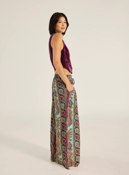 Step into style with the Valentina Pant, a wide- leg palazzo design featuring a charming ruffle edge and a drawstring finish. With convenient side slash pockets, these versatile pants can be worn as a statement style or as luxe over- swim.