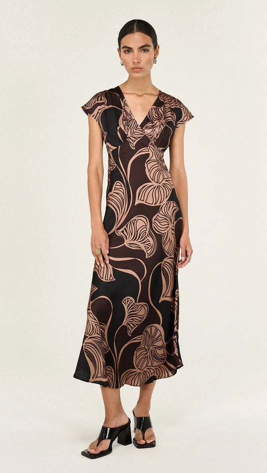The Abstract Leaf Print Bias Cut Midi Dress is designed to bring effortless elegance to occasion dressing. Cut on the bias, this style drapes beautifully over the body, creating a flattering, fluid silhouette. 