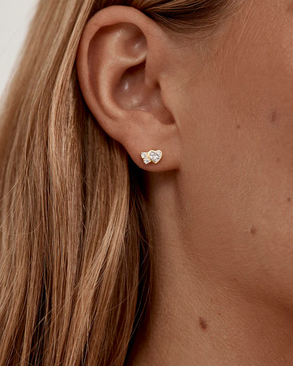 The Dream Lover Heart Stud Earrings speaks to the unspoken connections and the in-between moments of utmost intimacy. The delicate heart cluster design encapsulates the dreamy moments of tender love and connections we hold closest to our hearts.&nbsp;

18k Gold Vermeil: 2.5 microns of 18 carat gold coating a sterling silver base.&nbsp;

Features heart (bezel setting) and round (claw) cut cubic zirconias.&nbsp;

Sold as a pair.&nbsp;

Size: 7 x 5mm.&nbsp;

Polished finish.&nbsp;