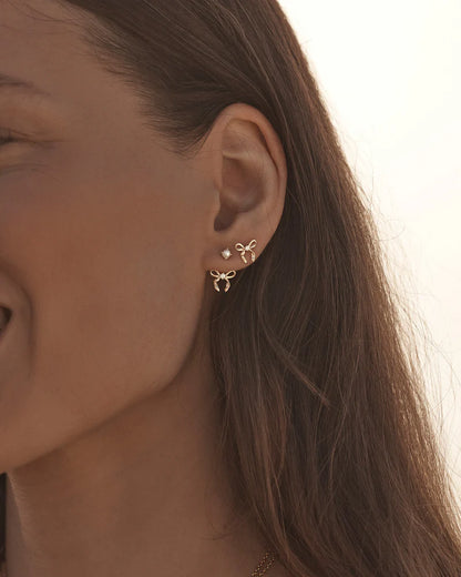 By Charlotte - The Forever More Bow Stud Earrings are a playful and delicate ode to love and romance. This keepsake is a tangible expression of the saying "tied together", with the bows symbolising love, cherished bonds, and devotion.&nbsp;

18k Gold Vermeil: 2.5 microns of 18 carat gold coating a sterling silver base.&nbsp;

Delicate bow design set with a sparkling cubic zirconia.&nbsp;

Sold as a pair.&nbsp;

9 x 8mm.&nbsp;

Polished finish.&nbsp;