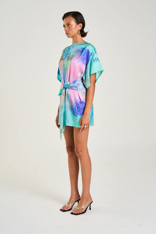 Your new “throw it on and instantly look styled” moment just dropped.

The Summi Summi Tie Front Dress – H20 Print brings wearable art into everyday dressing, featuring a hand-painted-inspired design that feels fresh, expressive, and effortlessly cool. It’s the kind of mini that turns heads quietly, no loud effort needed.