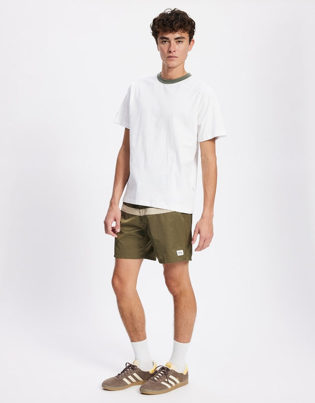 Inspired by vintage surf culture and built for modern adventure, the Market Trunks deliver effortless coastal style with everyday versatility. Crafted from recycled nylon for a lightweight yet durable feel, these trunks are designed to move with you — from the ocean to the street.

Featuring a contrast stripe design and a classic fixed waistband with a secure drawcord closure, they offer a timeless look with a tailored fit. Quick-drying and functional, they’re perfect for surf sessions, beach hangs, or week